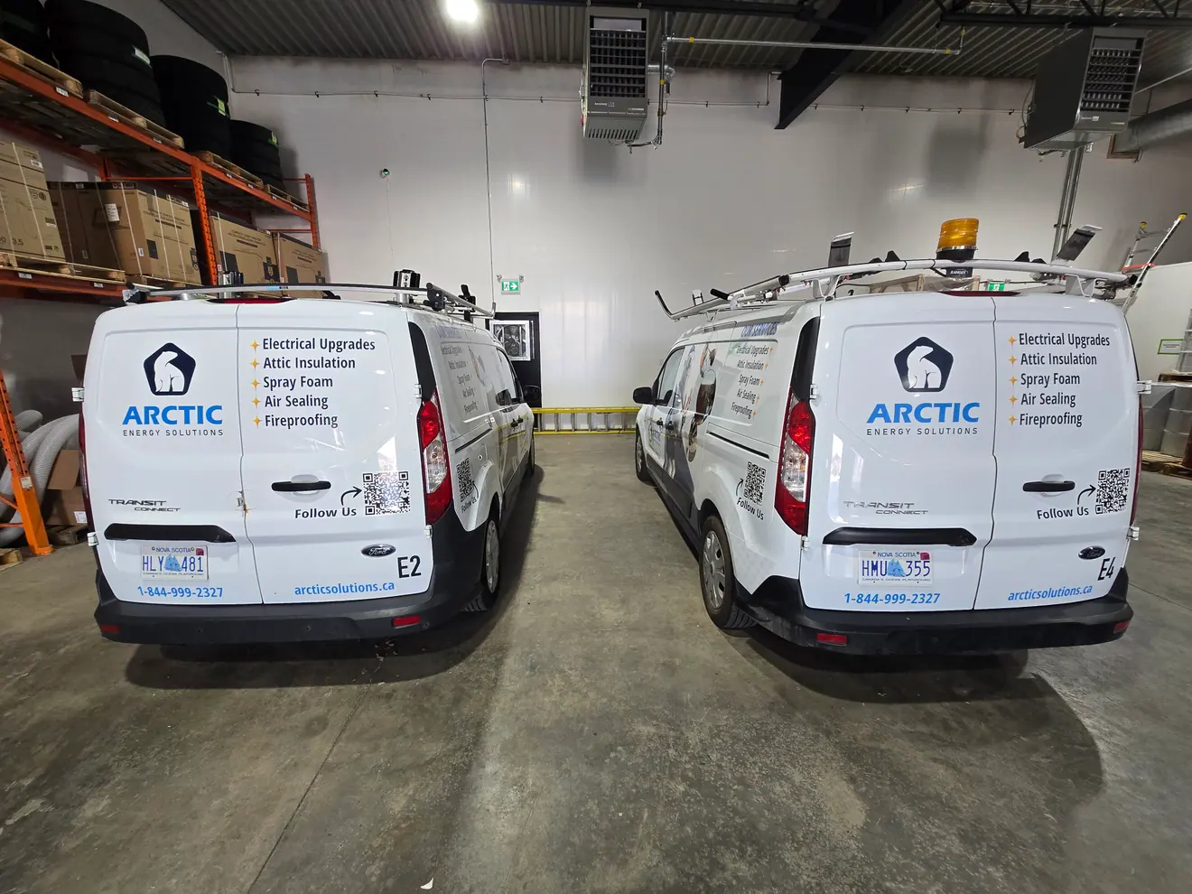 Two matching Arctic Energy service vans lettered by ProFleet Graphics, parked in the shop